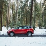 red suv on snow covered road during daytime